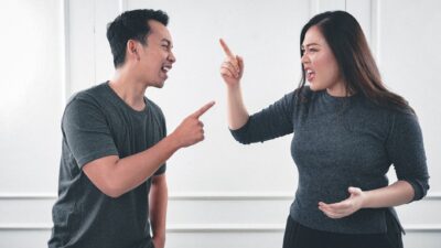 Illustrasi pasangan pasif agresif sedang berdiskusi dengan ekspresi tegang.