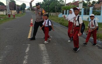 Bhabinkamtibmas Polsek Utan Berikan Pelayanan Prima dengan Membantu Anak-Anak Sekolah Menyeberang Jalan