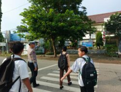 Personel Sat Lantas Polres Bima Kota Bantu Anak Sekolah Menyeberang Jalan