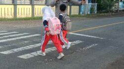 Wujud Polisi Humanis, Brigadir Wawan Satria Atur Lalu Lintas Saat Anak Sekolah di Desa Goa