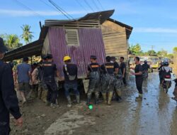 Bahu Membahu, Brimob Pindahkan Rumah Terseret Banjir yang Melintang di Jalan Nasional Tamiang–Langsa