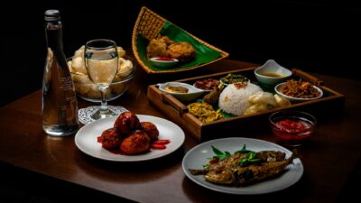 Contoh globalisasi di bidang kuliner berupa sajian makanan cepat saji populer di atas meja.