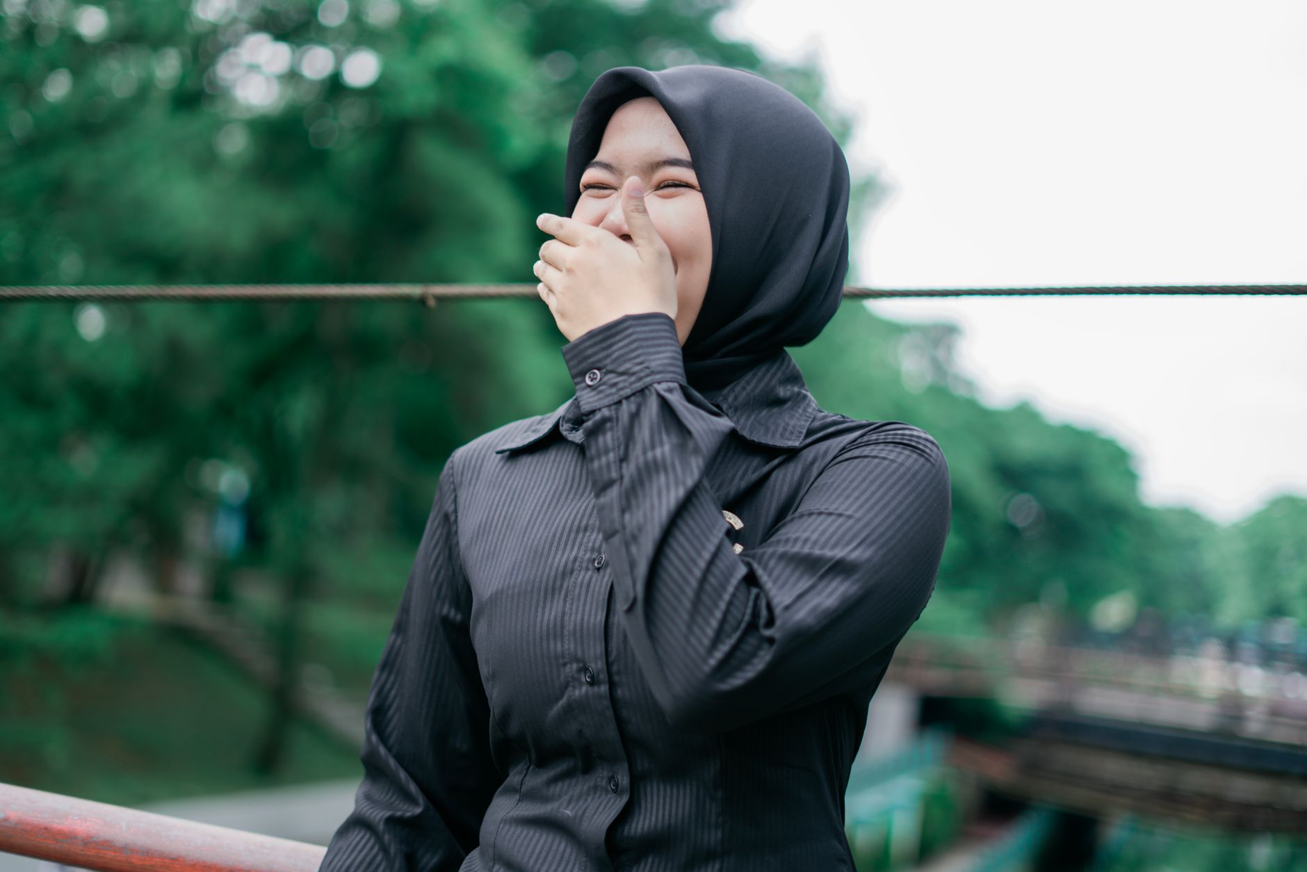 Seseorang tersenyum tenang saat membalas sindiran dengan elegan.