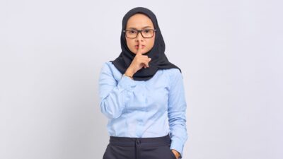 Ilustrasi seseorang menjaga rahasia asmara dengan berhati-hati saat berbicara.