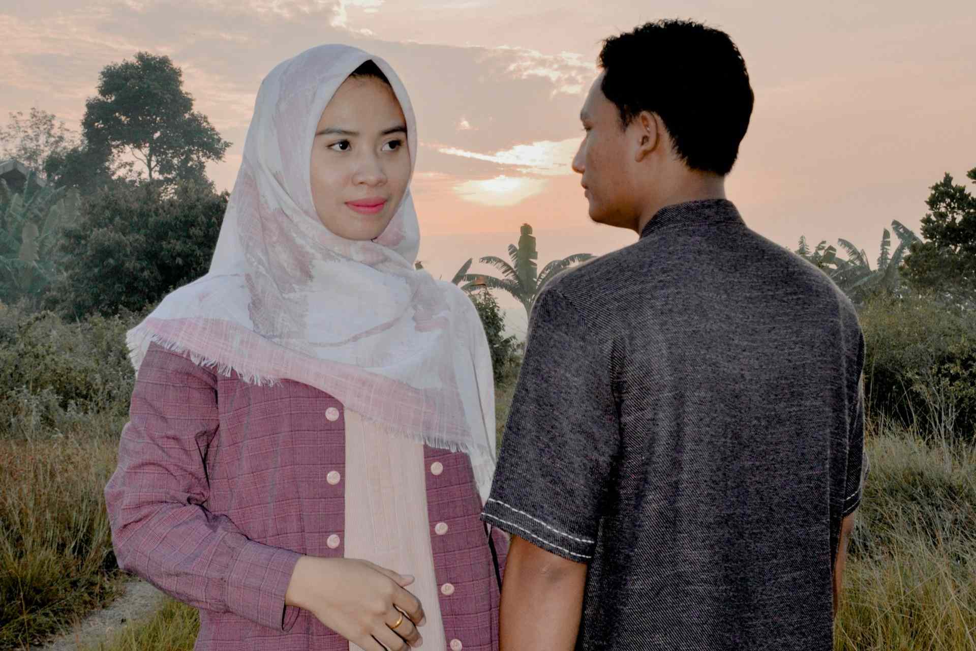 Pasangan suami istri tersenyum hangat, menggambarkan tips menjaga keintiman pernikahan yang sering diabaikan.