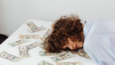 Person looking stressed while holding a calculator and bills, representing financial anxiety.
