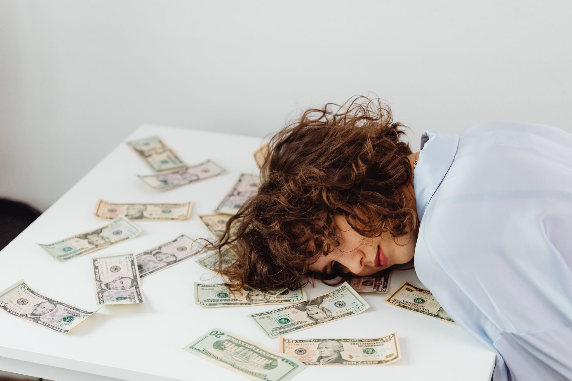 Person looking stressed while holding a calculator and bills, representing financial anxiety.
