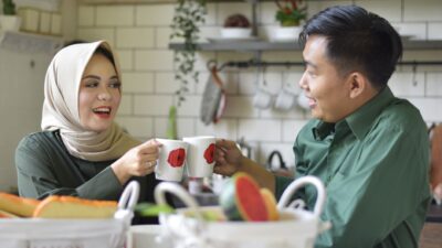 Kebiasaan pasangan bahagia menikmati kopi bersama di dapur yang nyaman.