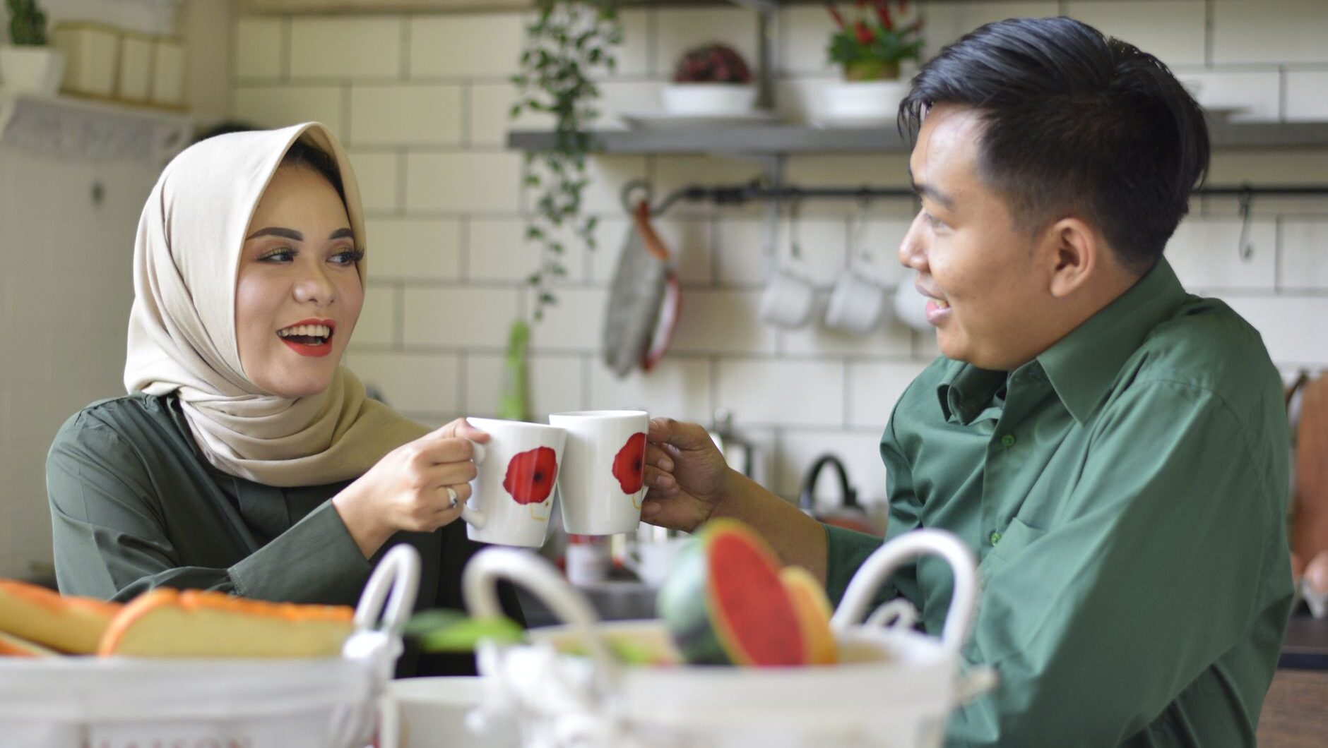 Kebiasaan pasangan bahagia menikmati kopi bersama di dapur yang nyaman.
