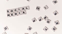 Scrabble tiles spelling "SOCIAL MEDIA" on a white background, surrounded by scattered letter tiles.