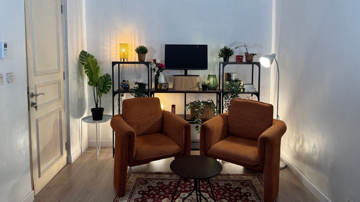 Cozy minimalist living room interior showcasing comfortable penataan rumah with armchairs and shelving.
