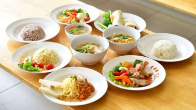 Berbagai hidangan makanan sehat tertata di atas meja kayu.