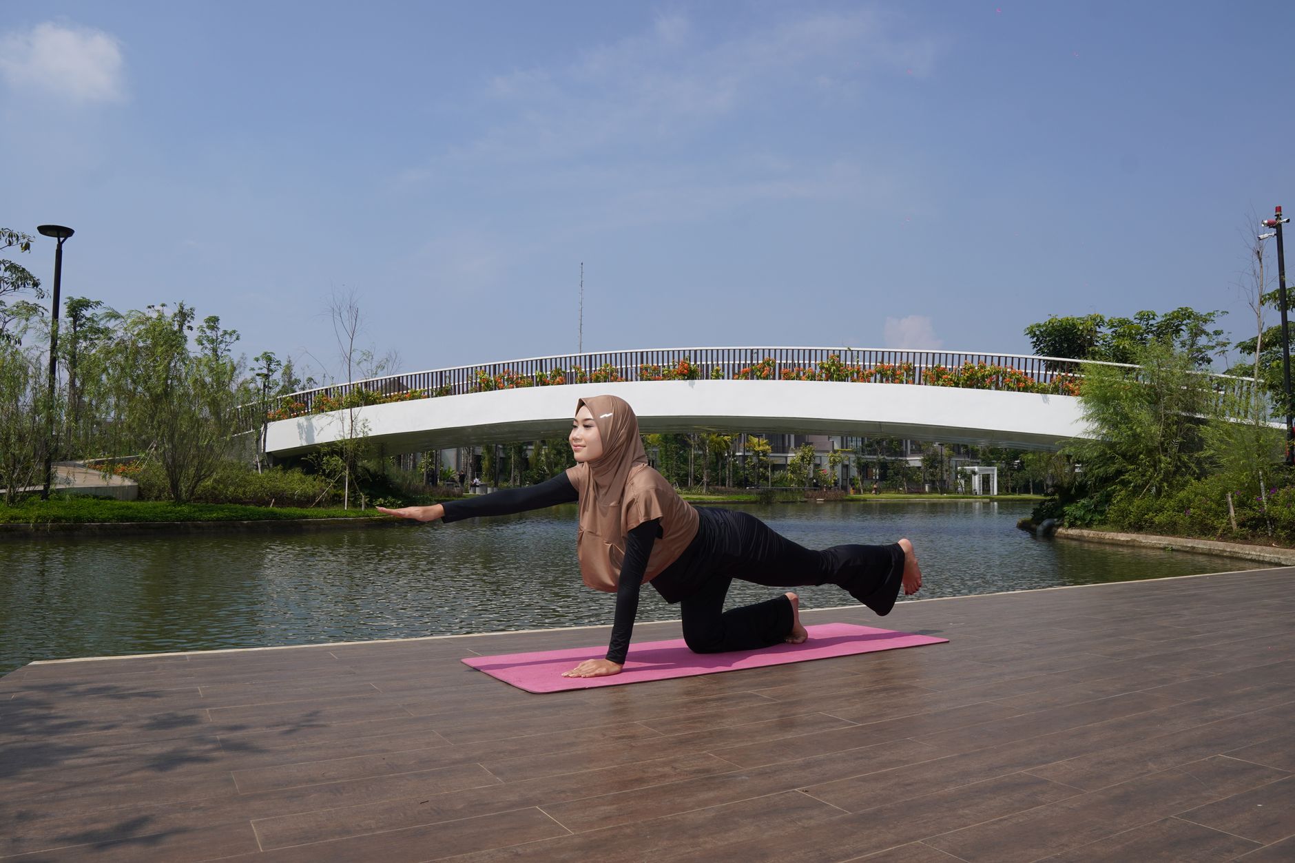 Wanita berhijab melakukan yoga di tepi Danau sebagai bagian dari gaya hidup sehat.
