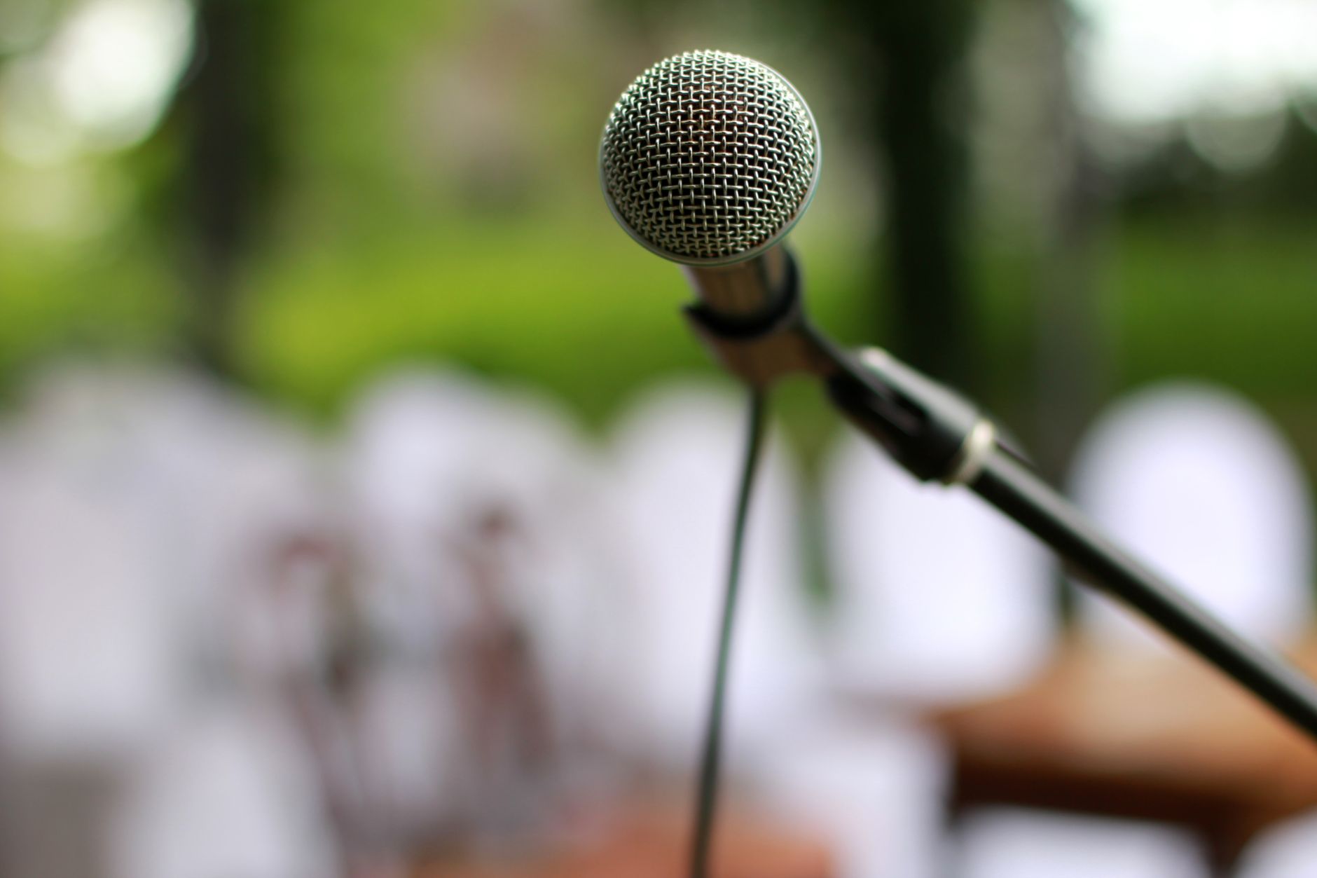 A silver microphone on a stand with a blurred background for tips public speaking.