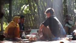 Orang-orang berkumpul di area luar ruangan yang asri untuk menggambarkan topik Kecemasan Sosial.