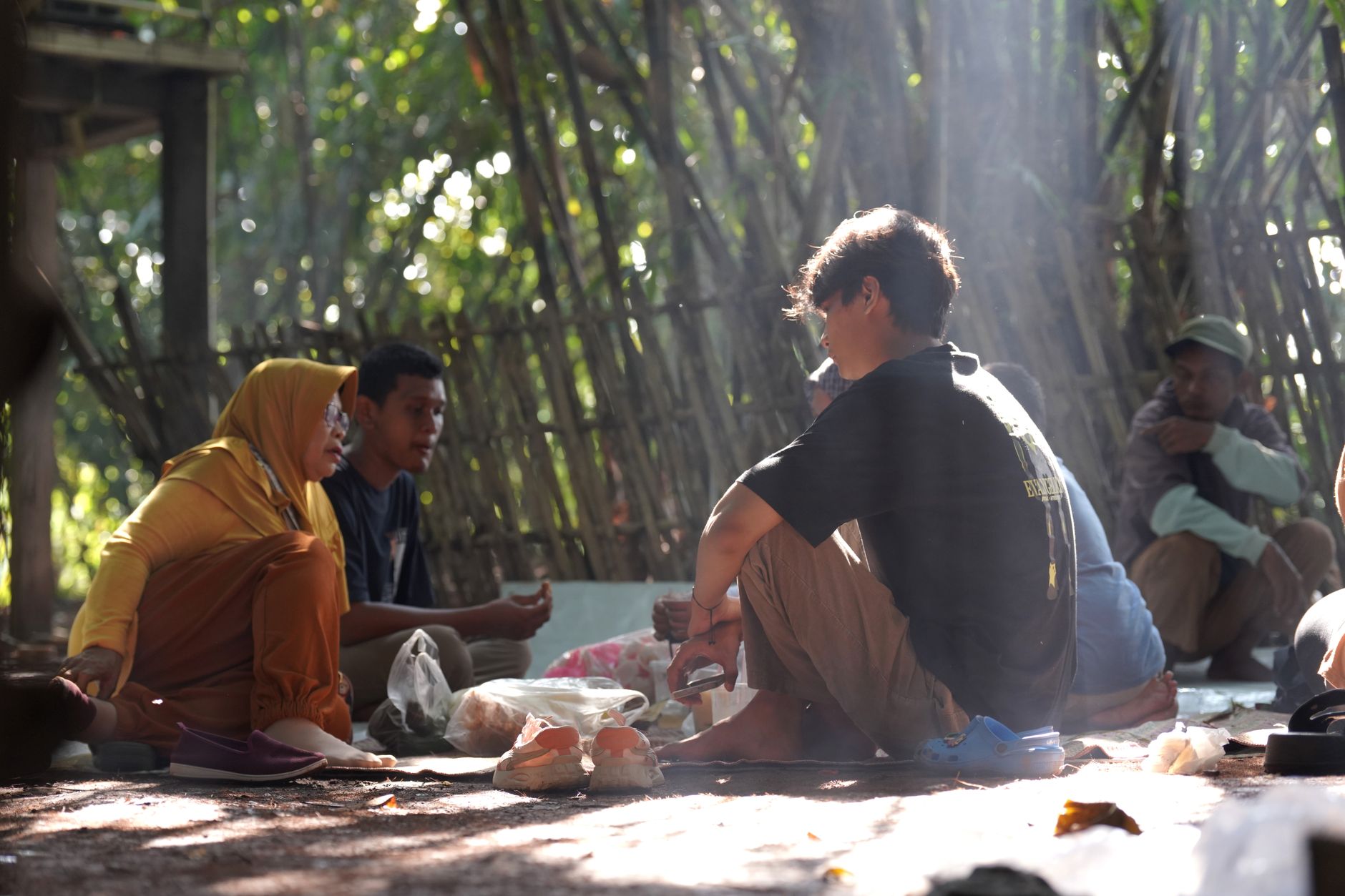 Orang-orang berkumpul di area luar ruangan yang asri untuk menggambarkan topik Kecemasan Sosial.