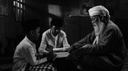 Elderly man guiding two young boys reading a holy book indoors, representing traditional nasihat orang tua.