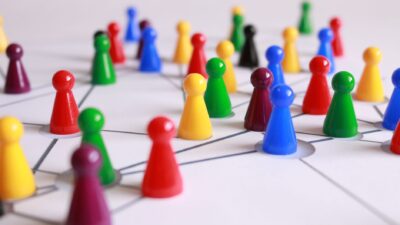 Colorful game pieces connected by drawn lines on a white sheet, representing business networking.