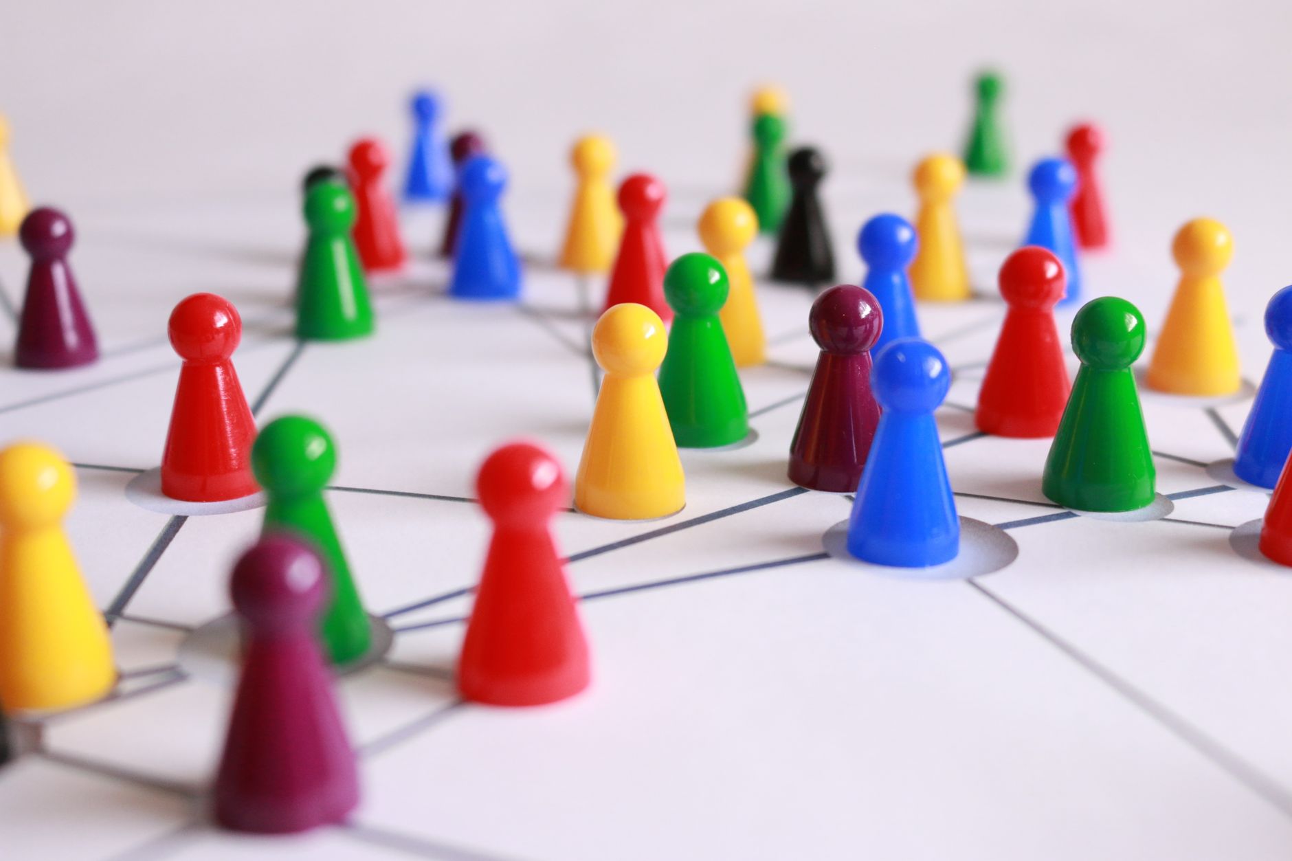 Colorful game pieces connected by drawn lines on a white sheet, representing business networking.