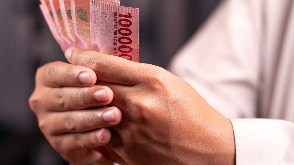 Seseorang memegang lembaran uang rupiah untuk mengatasi kebuntuan finansial bulanan.