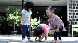 Ayah dan anak yang tersenyum bersama, menunjukkan kemiripan wajah yang kuat terkait genetika anak.