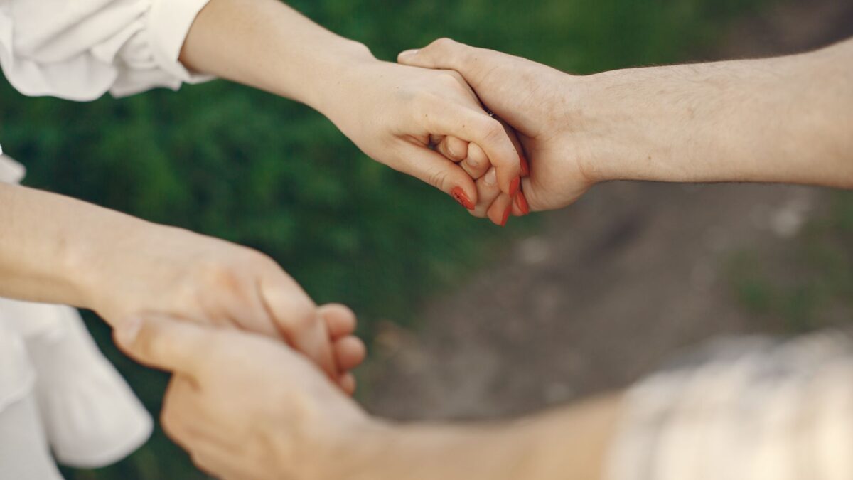 A couple holding hands in a park, illustrating Karmic Relationship dynamics.