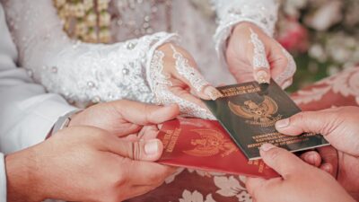 Pasangan pengantin baru di Indonesia memamerkan buku nikah mereka sebagai simbol kesiapan menikah.